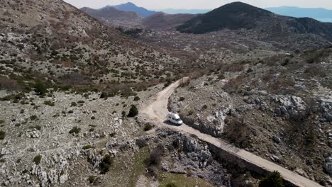 driving rv on mountain gravel road against rolling hills, park prirode biokovo