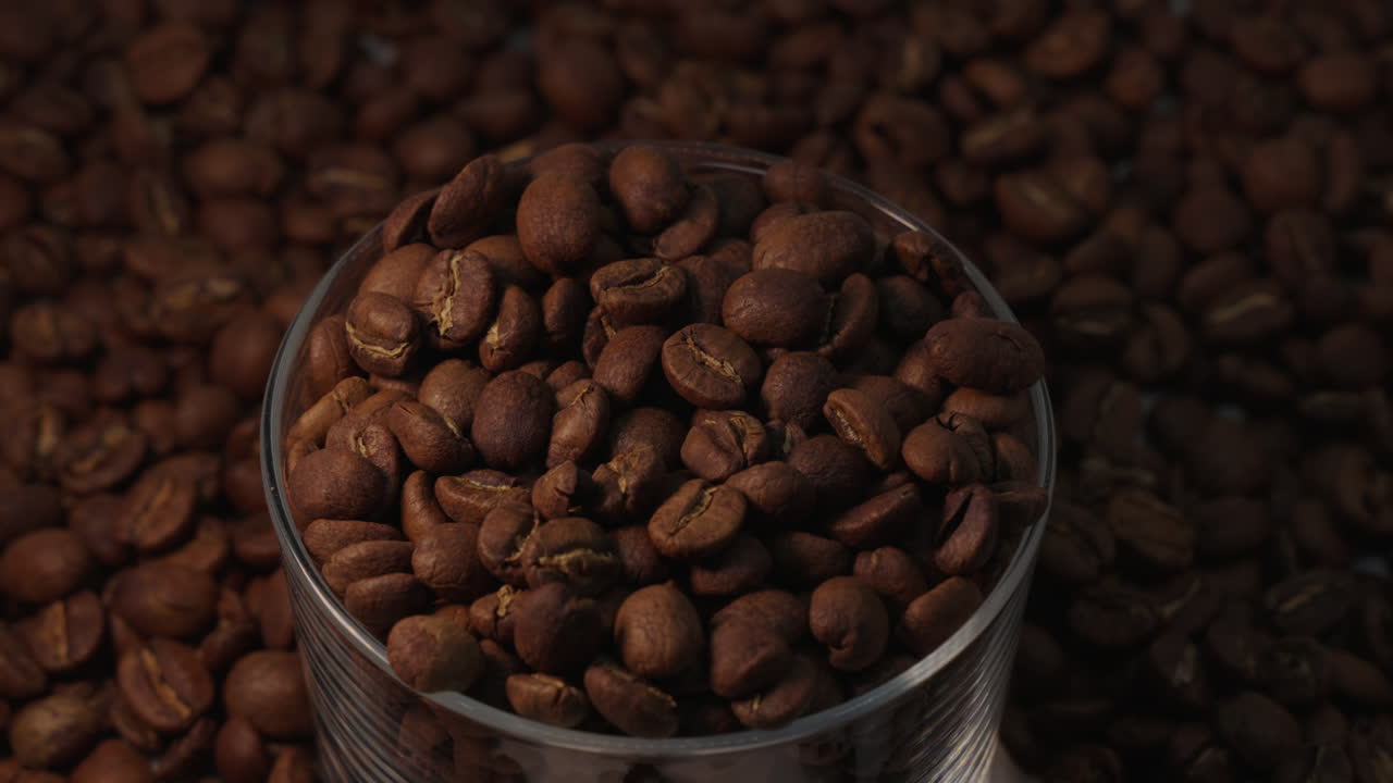 Immagine statica di chicchi di caffè in una tazza, con luce dorata che brilla lateralmente