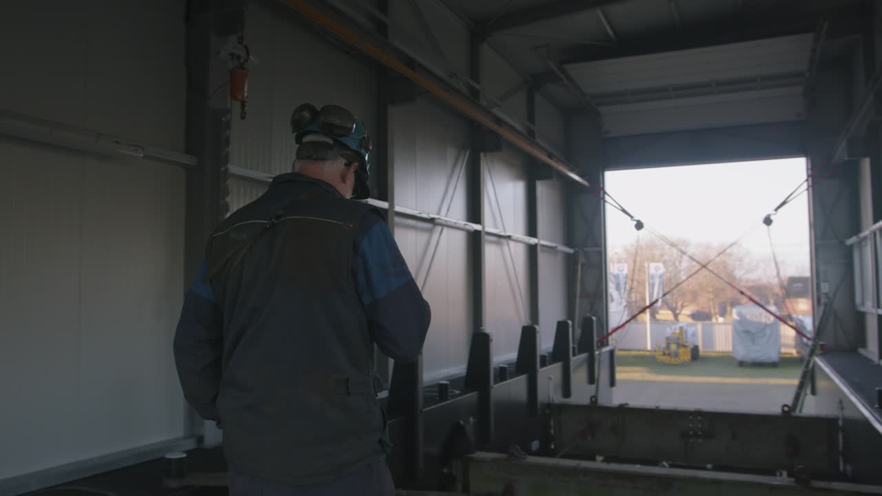 Supervisor overseeing the loading process and securing cargo in large container, back view