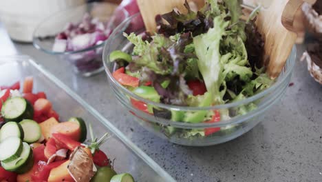 close up of chopped vegetables and salad on worktop in kitchen, slow motion