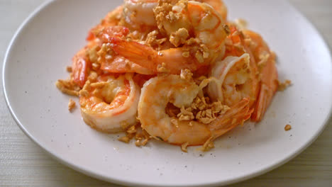 fried shrimps or prawns with garlic on white plate - seafood style