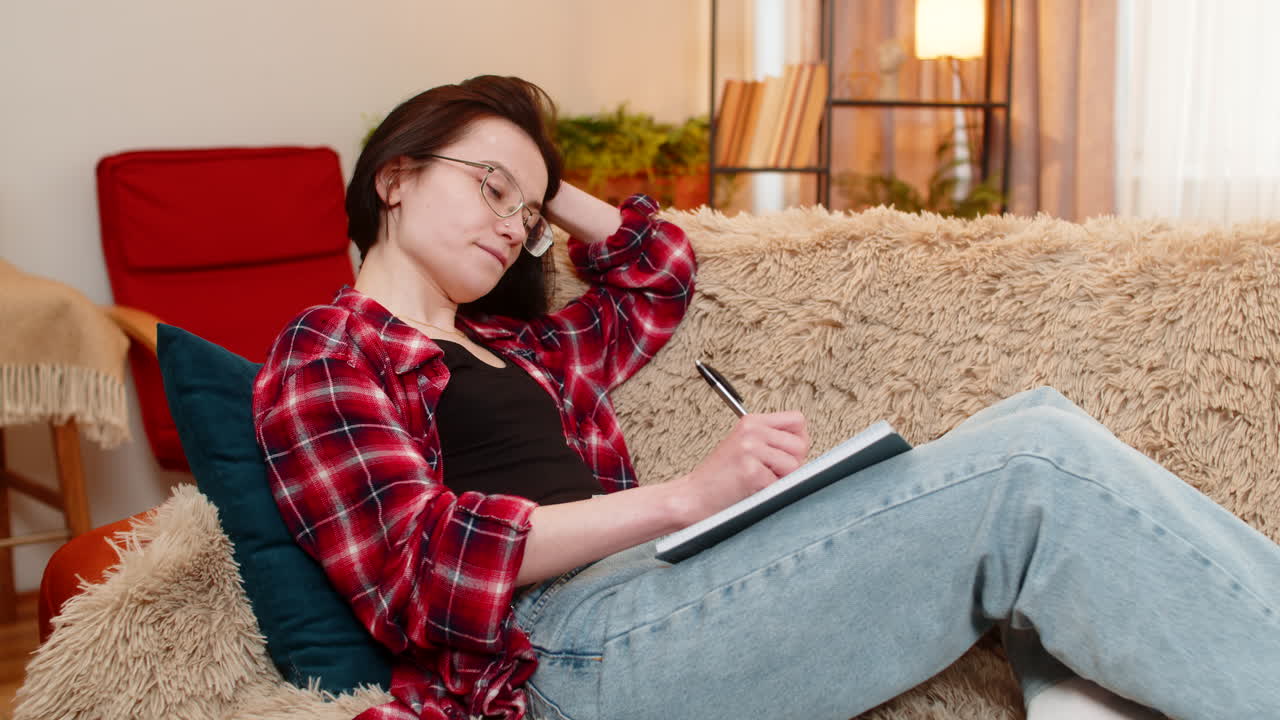 Creative woman sketching in notebook at home focused inspired by creative process with calm energy