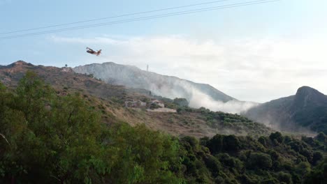 avión de extinción de incendios tirando agua en las montañas
