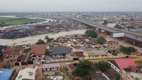 aerial view neighbourhood in lagos nigeria on a hazy day with drone moving away from the slum bridge towards