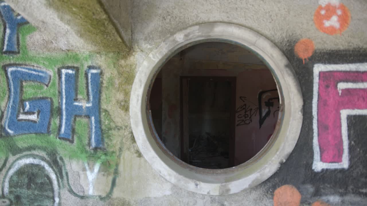 Suspense, handheld dolly movement through a window inside of an abandoned building.