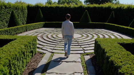 a person walking through a circular maze in a garden