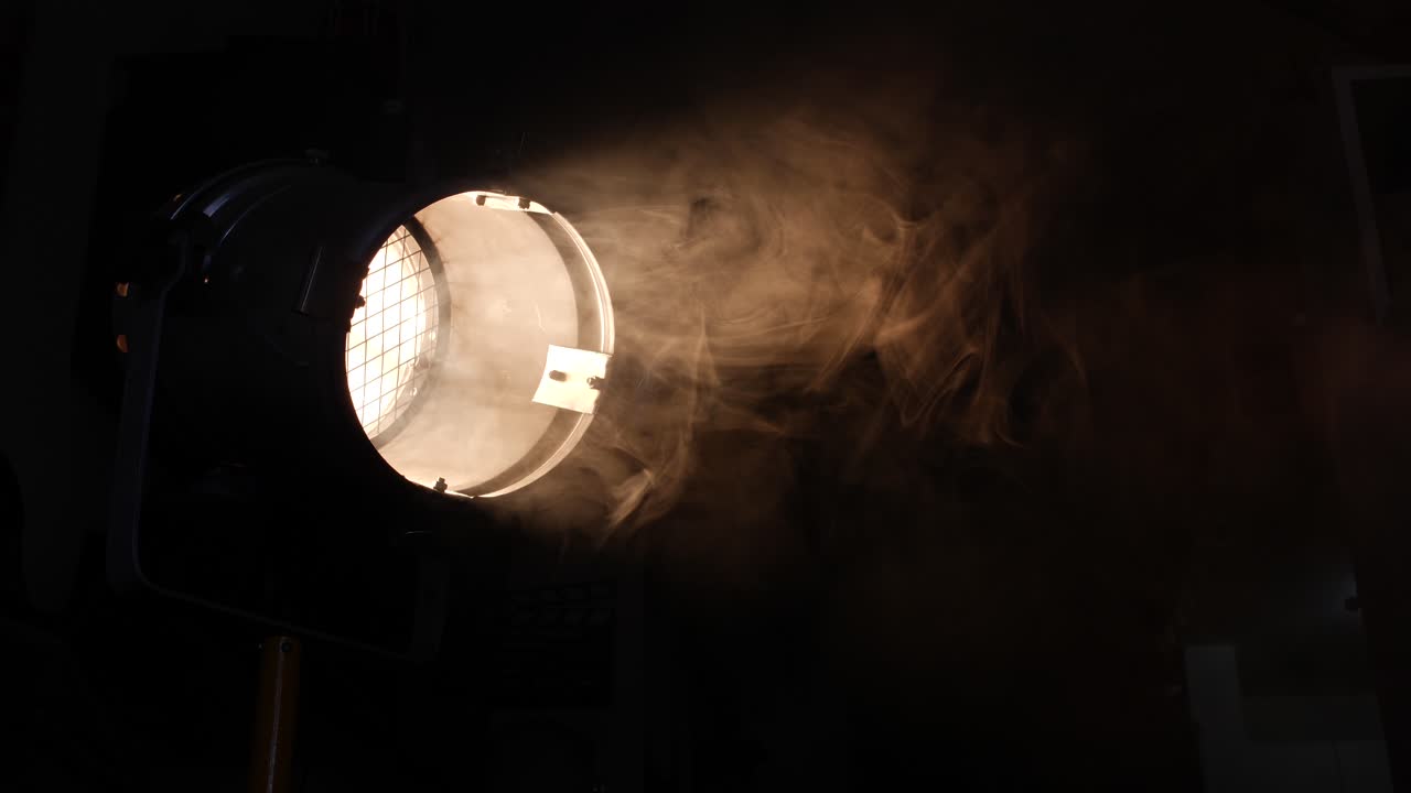 Haz de luz dramático atravesando el humo en un plató de cine