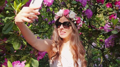 woman takes slow motion selfie in blooming garden with matching floral phonecase