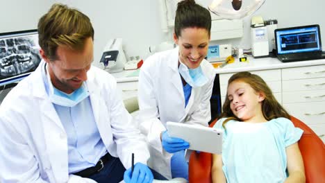 dentista mostrando una tableta digital a un paciente joven