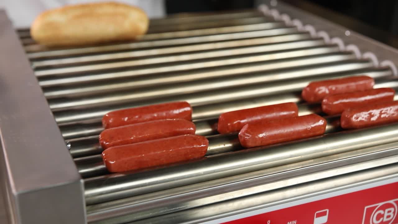 preparando perritos calientes en una máquina de perritos calients