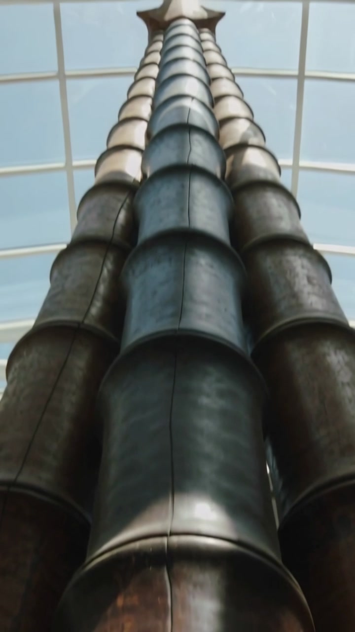 Vertical video: Close focus pull, cam pulling back, tilting to reveal metal column under skylight