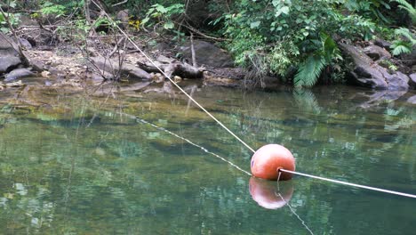 orange buoy floating on clear water. 4k