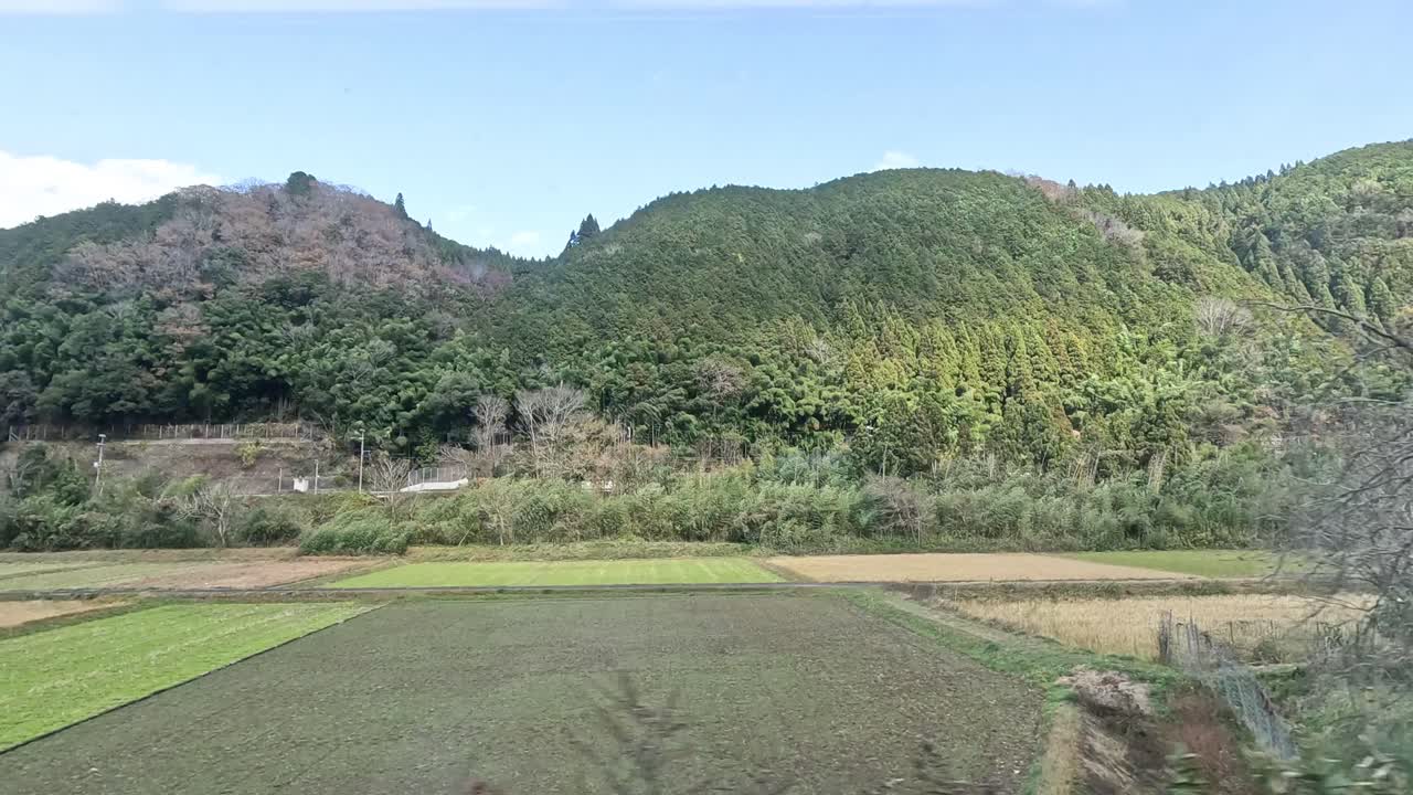 Passing through lush fields and hills by train.