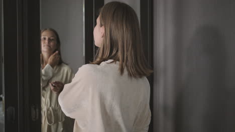 woman getting ready in front of a mirror