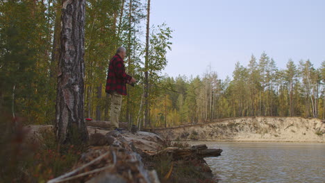 Der-Fischer-Genießt-Die-Natur-Und-Die-Ruhe-Im-Wald-Beim-Spinnfischen-Am-Ufer-Des-Sees-Am-Frühen-Herbsttag-Beim-Angeln