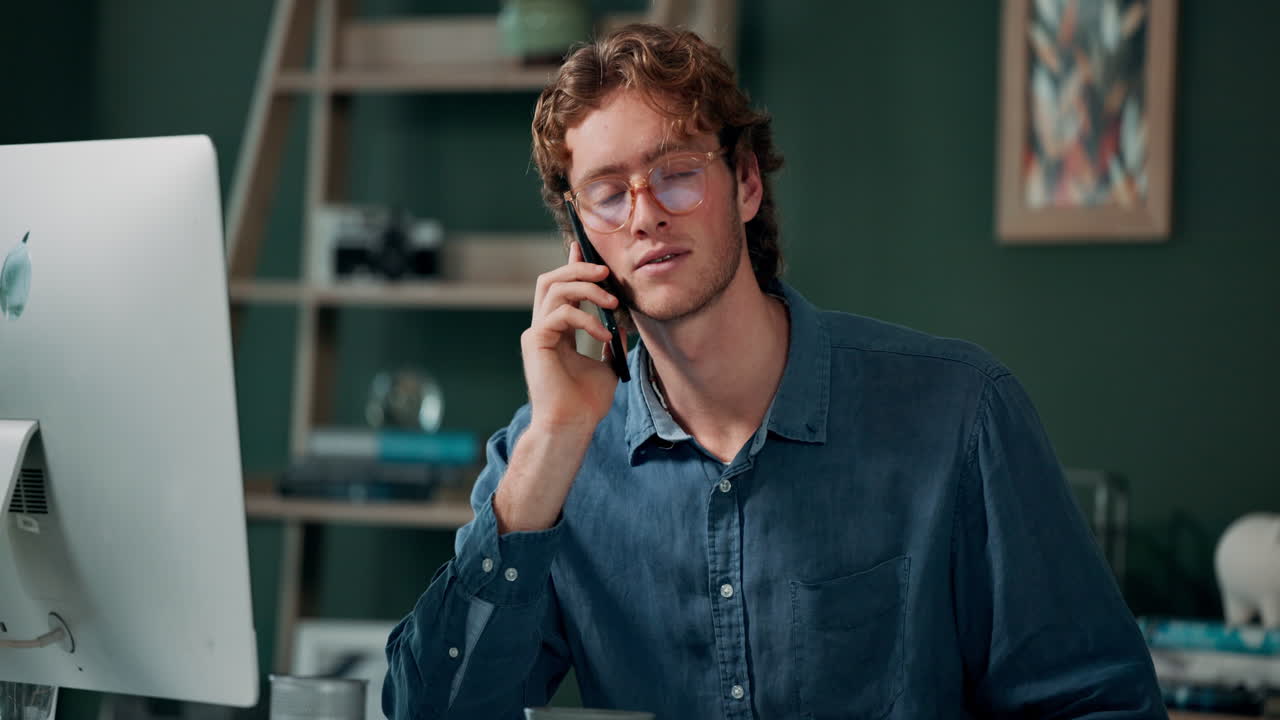 그의 책상에서 전화 통화를 하는 남자