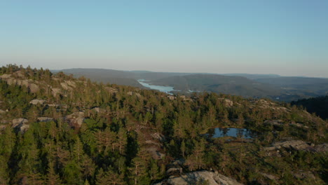 aerial drone shot flying over picturesque norwegian mountains with alpine lake