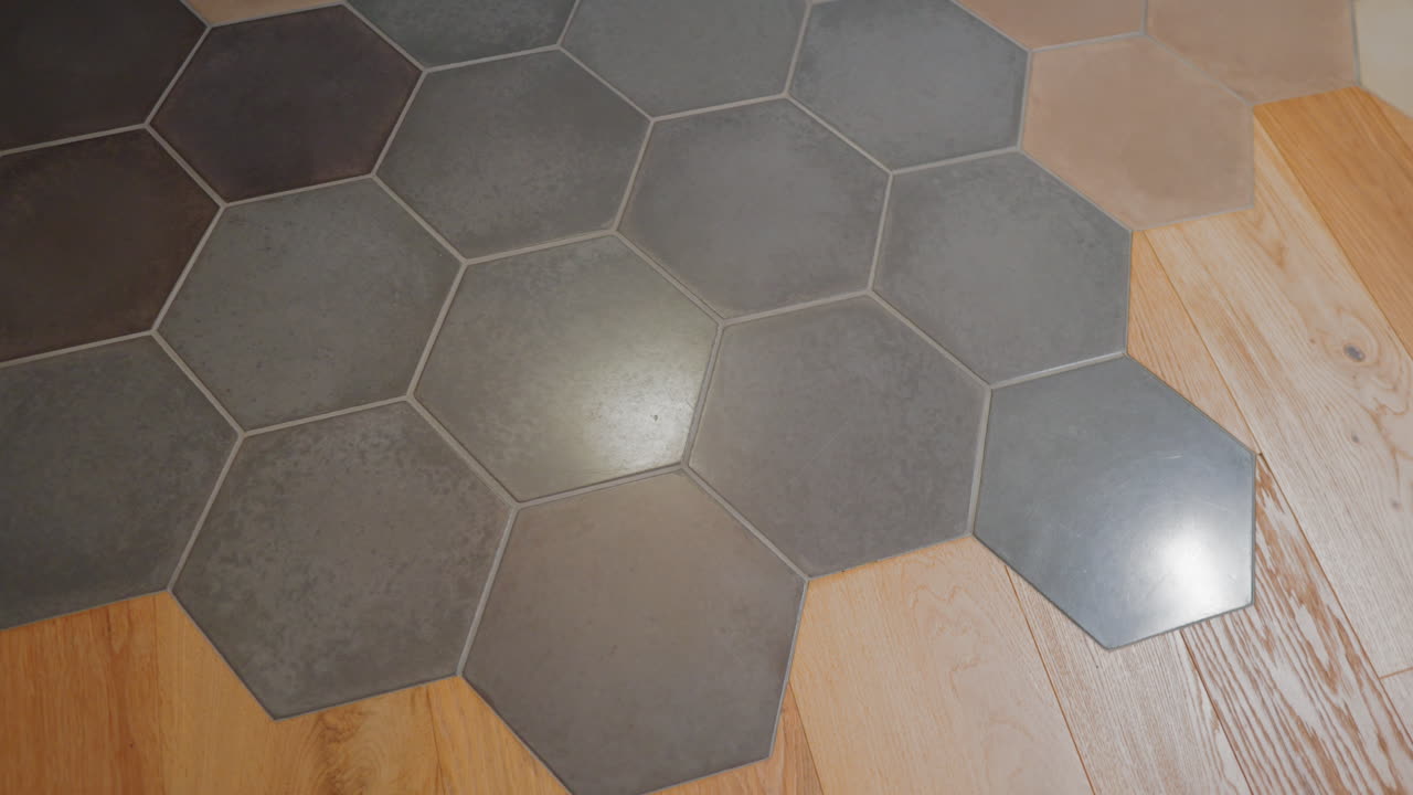 un suelo moderno con baldosas hexagonales grises y parquet marrón claro