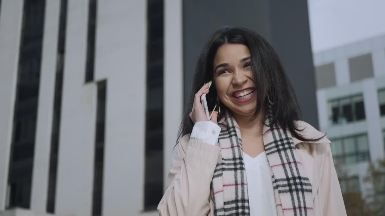 Businesswoman talking smartphone on street. Female professional using cellphone