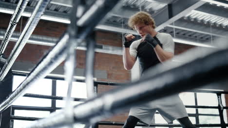 Progressive-fighter-getting-ready-for-battle-at-gym.-Kickboxer-training-kicks