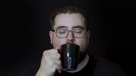 Motion-Studio-Portrait-Eines-Bärtigen-Mannes,-Der-Einen-Befriedigenden-Schluck-Kaffee-Genießt