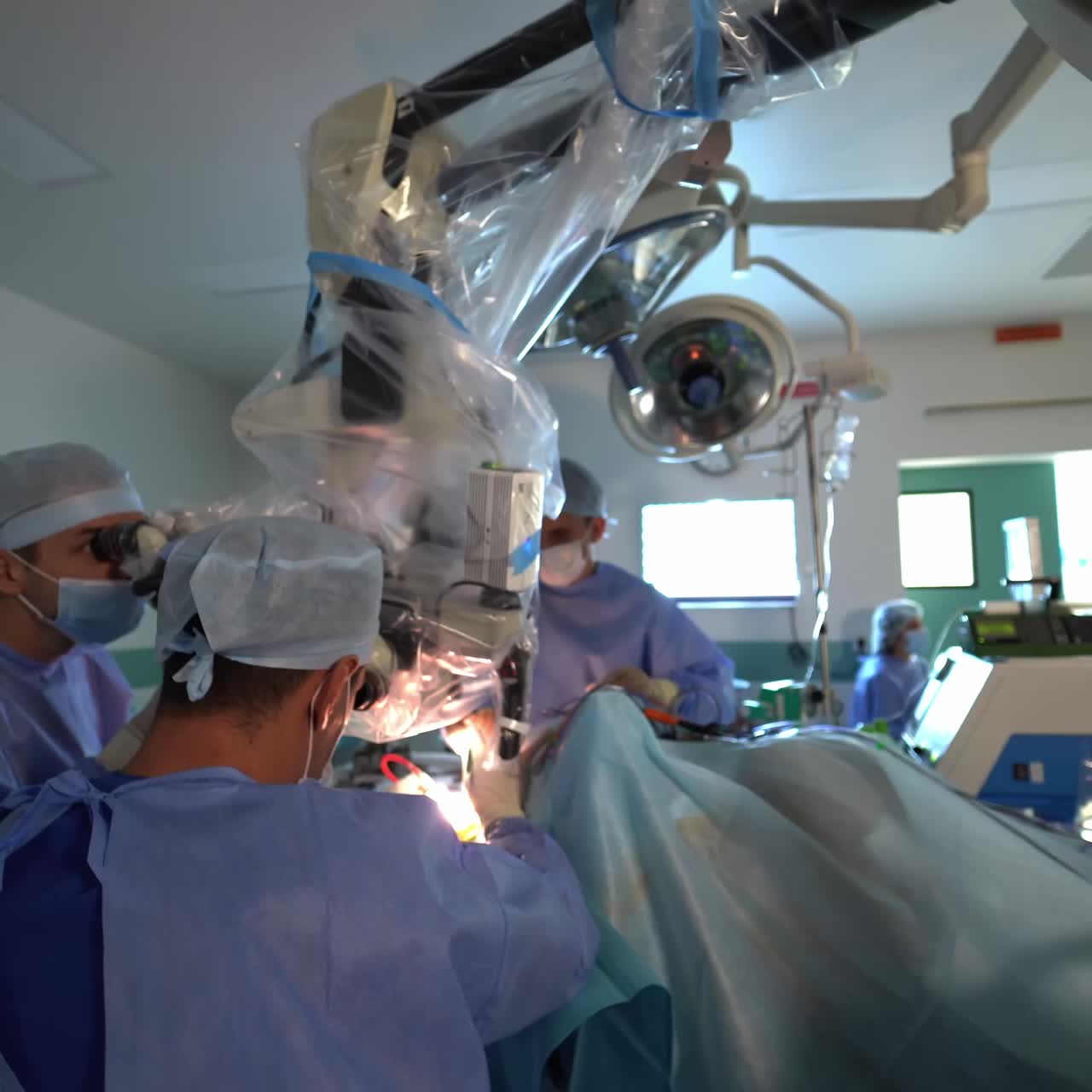 A team of surgeons working seated at the neurosurgical operations. Innovative equipment in the modern operating room