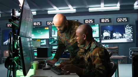 Military-dispatcher-helped-by-coworker-with-tablet