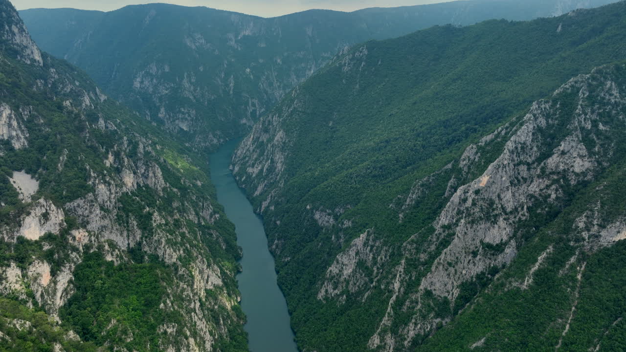 A river runs through a canyon The aerial view of a canyon walls have green trees and rock formations