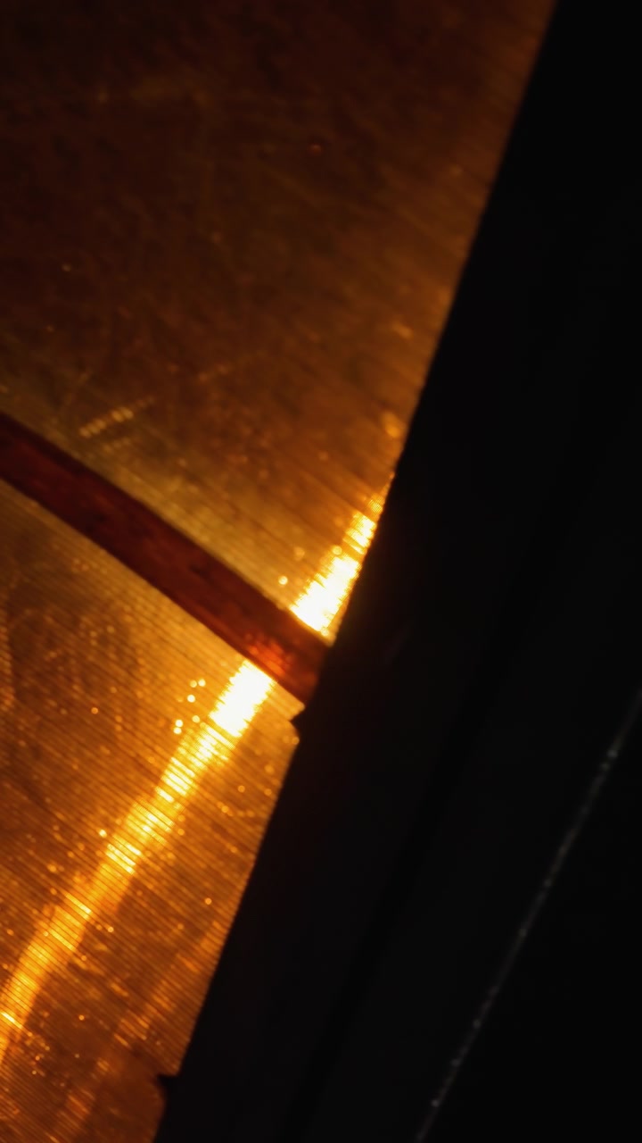 Close-up abstract night view featuring glowing lights and reflective surfaces, with bright light effects and dark shadows