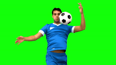 handsome man controlling a football with his chest on green screen