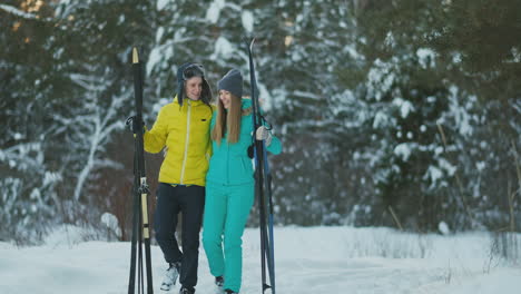 loving guy and girl skiing in winter forest in slow motion smiling and looking at each other