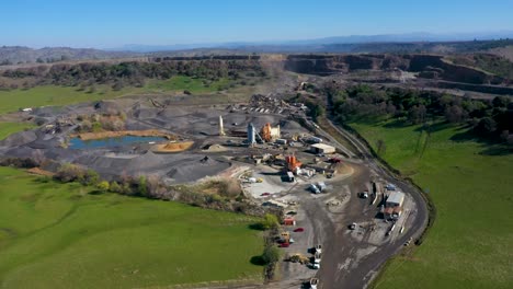 aerial orbit shot of a quarry and aggregate processing plant in the foothills