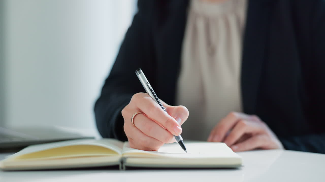 Businesswoman writing in notebook