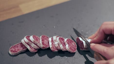 spanisches vergnügen: mädchen schneidet fuet salami aus der nähe