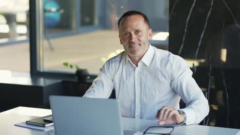 Hombre-De-Negocios-Sonriente-Trabajando-En-Una-Computadora-Portátil-En-La-Oficina.-Profesional-Masculino-Escribiendo-En-El-Teclado-De-La-Computadora-Portátil-En-El-Lugar-De-Trabajo-De-La-Oficina