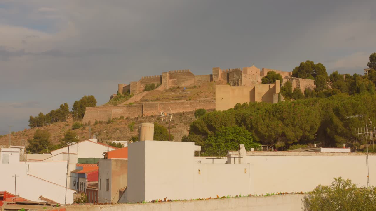 en primer plano la ciudad de calvary y en el fondo el castillo de sagunto en españa en un día soleado