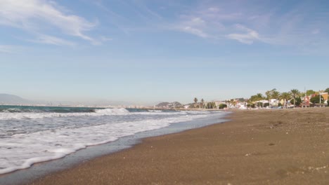 Eine-Aufnahme-Aus-Einem-Niedrigen-Winkel-Von-Einem-Schönen-Sonnigen-Strand-Am-Mittelmeer-In-Südspanien-Europa-Mit-Kleinen-Wellen-Und-Schleierwolken