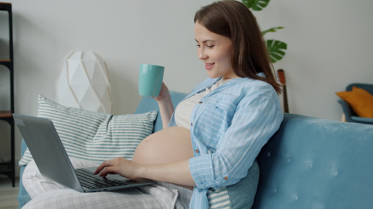 Pregnant woman working from home with laptop and coffee