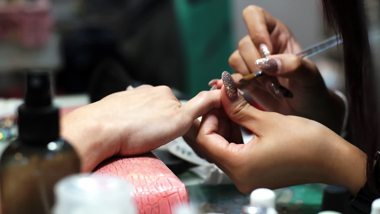 Close-up of a woman receiving a professional hand and nail manicure at a beauty salon. Focus on female hands, skincare, and nail care treatment