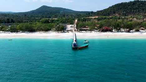 aerial of long tail boat docked at wooden pier on 4k beach, kong rong, cambodia