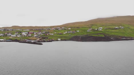 luftüberblick über einen fjord und ein kleines dorf auf den färöern