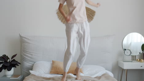 woman jumping on bed