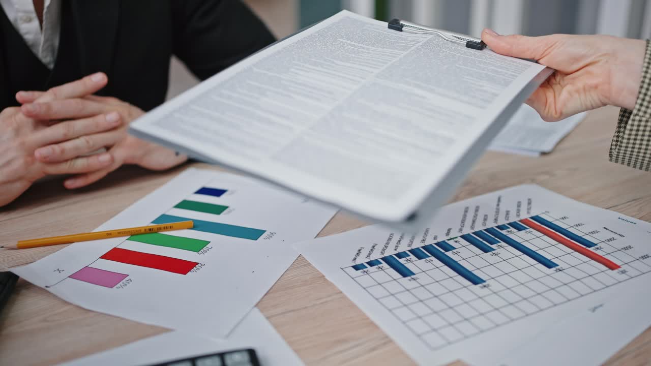 mujer de negocios irreconocible dando bloc de notas con documentos al socio masculino, discutiendo detalles en la oficina