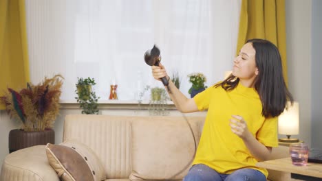 젊은 여성이  ⁇  건조기와 함께 노래하고 춤을 추고 있습니다.