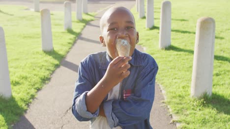 video de un niño afroamericano feliz comiendo helados en un día soleado