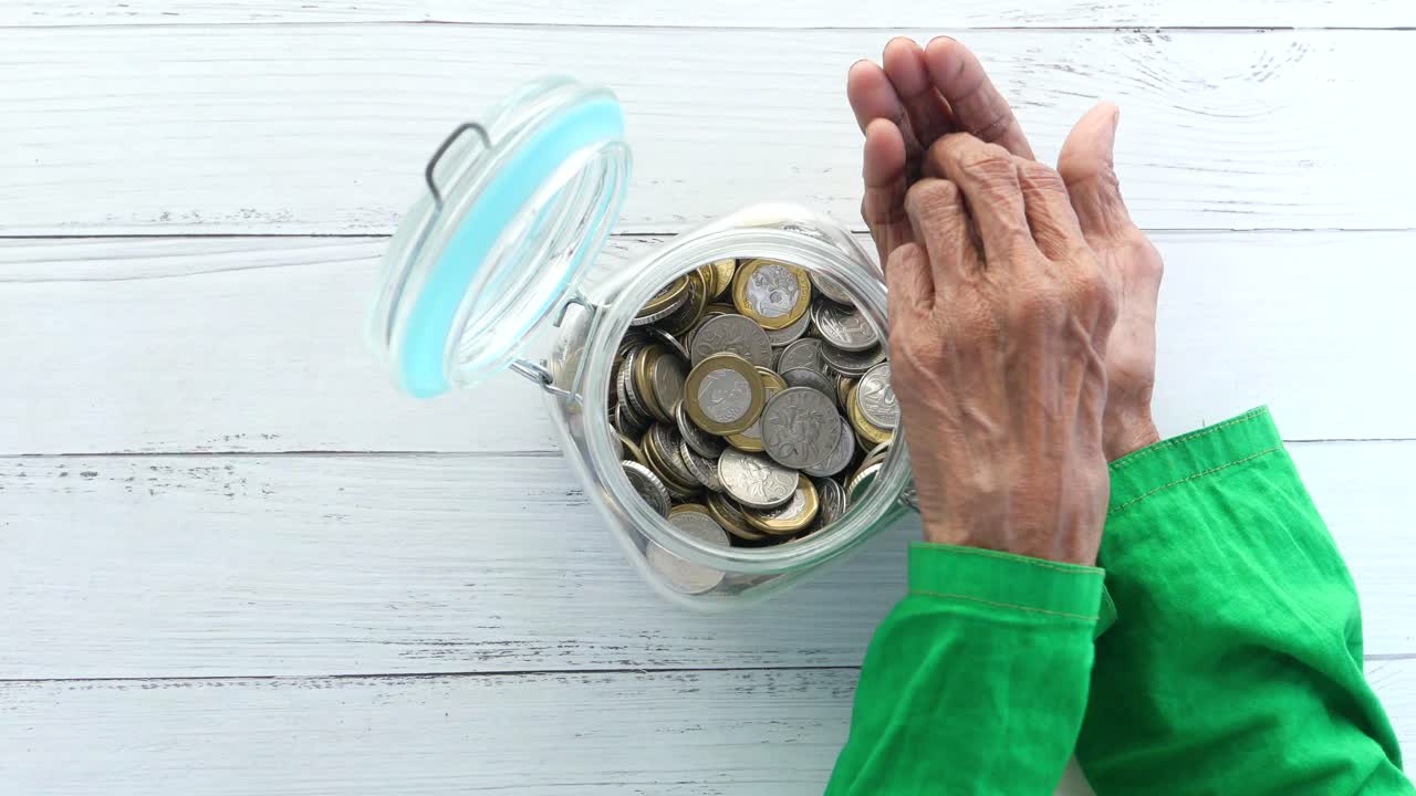 guardando monedas en un frasco de vidrio