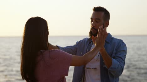 happy young mixed-race couple holding hands at beach 4k