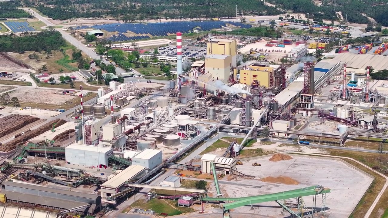 Industrial pulp and paper mill plant with a large biomass power facility. Aerial view showing the cellulose production process and logistics