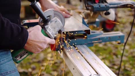 a married man cutting metal with angle grinder with sparks flying around in slowmotion