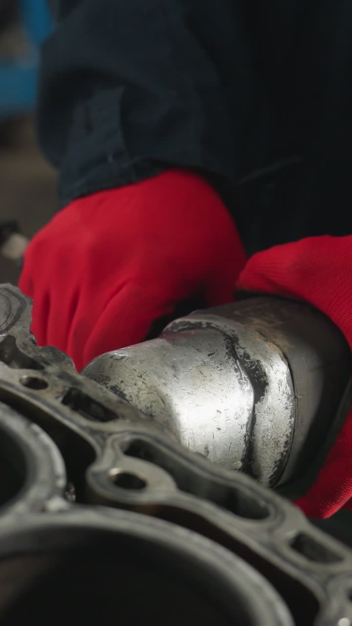 estudiante trabajando en una tableta mientras otro hombre se centra atentamente en una tarea en un taller industrial, el fondo presenta herramientas, equipos y espacio de trabajo mecánico